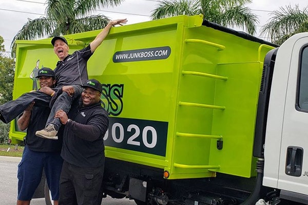 Happy Junk Boss employees beside the truck