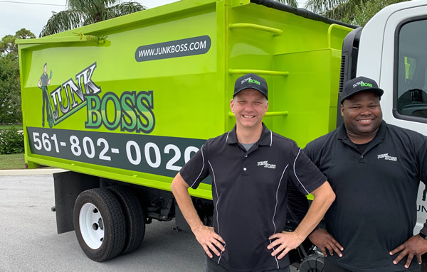 The Junk Boss owners, Jeremy and Brian, pose in front of a Junk Boss truck